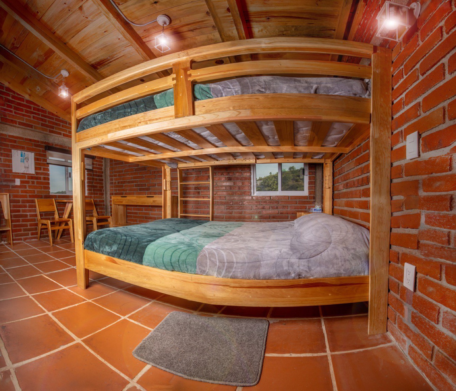 Recámara con litera y cama matrimonial, techo de madera abovedado