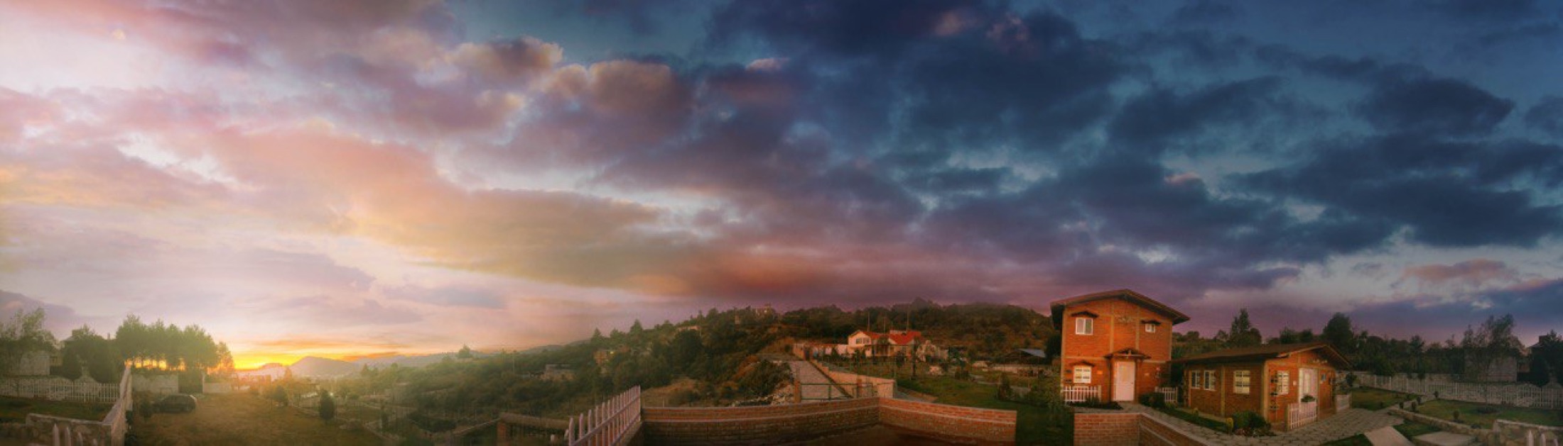 Atardecer panorámico sobre las cabañas y la sierra